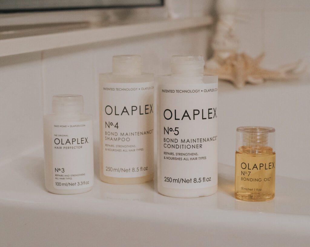 Olaplex hair products sit by a bathtub