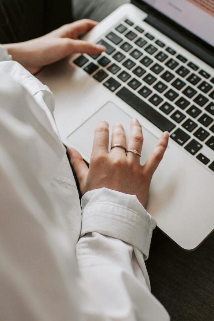 Woman working on a laptop indoors, focusing on document editing and remote work.